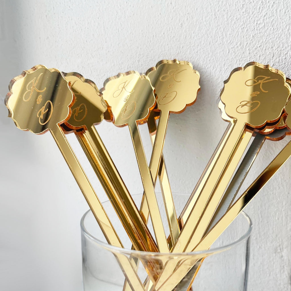 Gold mirror cocktail stirrers in a decorative shape with an exquisite design, on which initials are engraved to order.