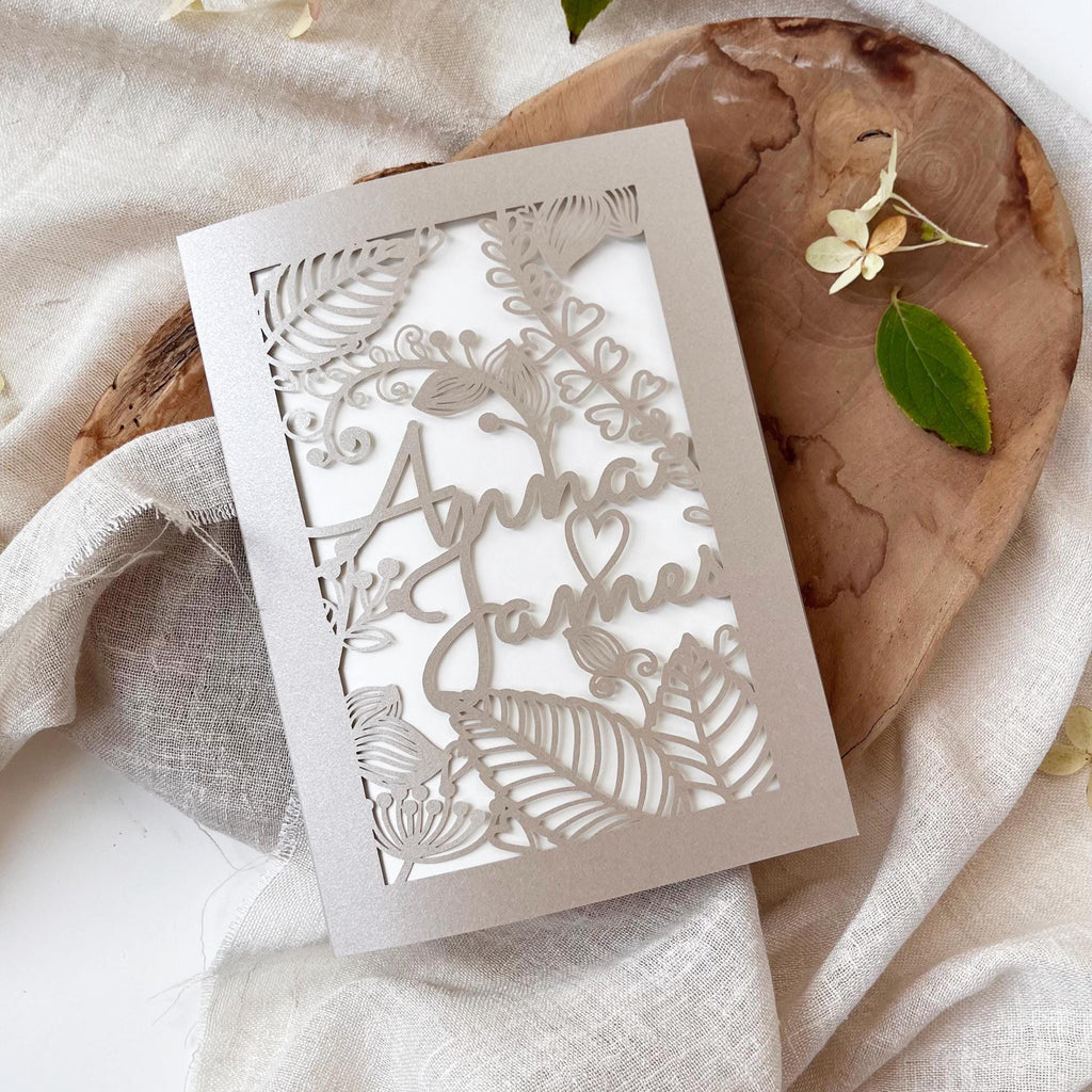 Laser cut 5x7 inch wedding invitation covers with floral design, personalized with custom names, available in burgundy, green, sand, and white.
