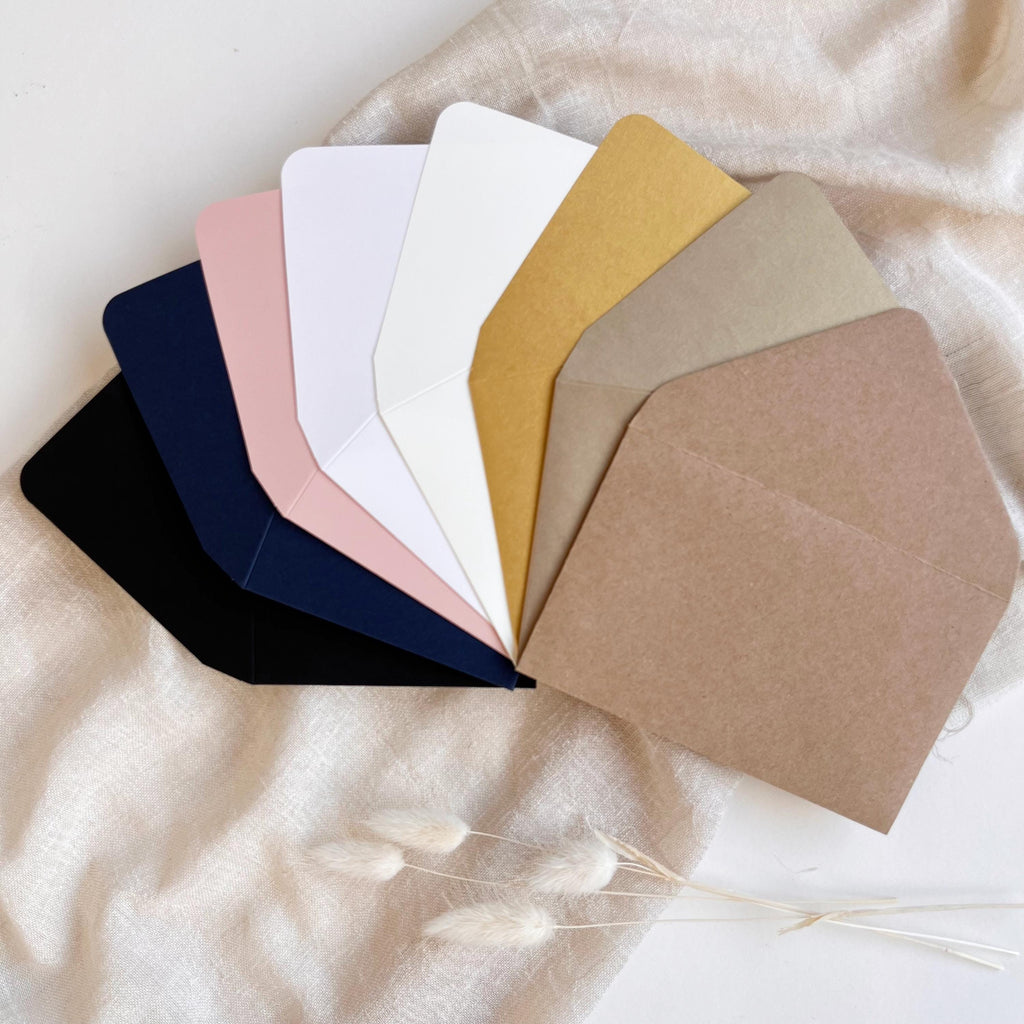 Old gold envelopes – one sealed with a wax seal, another open showcasing RSVP card inside